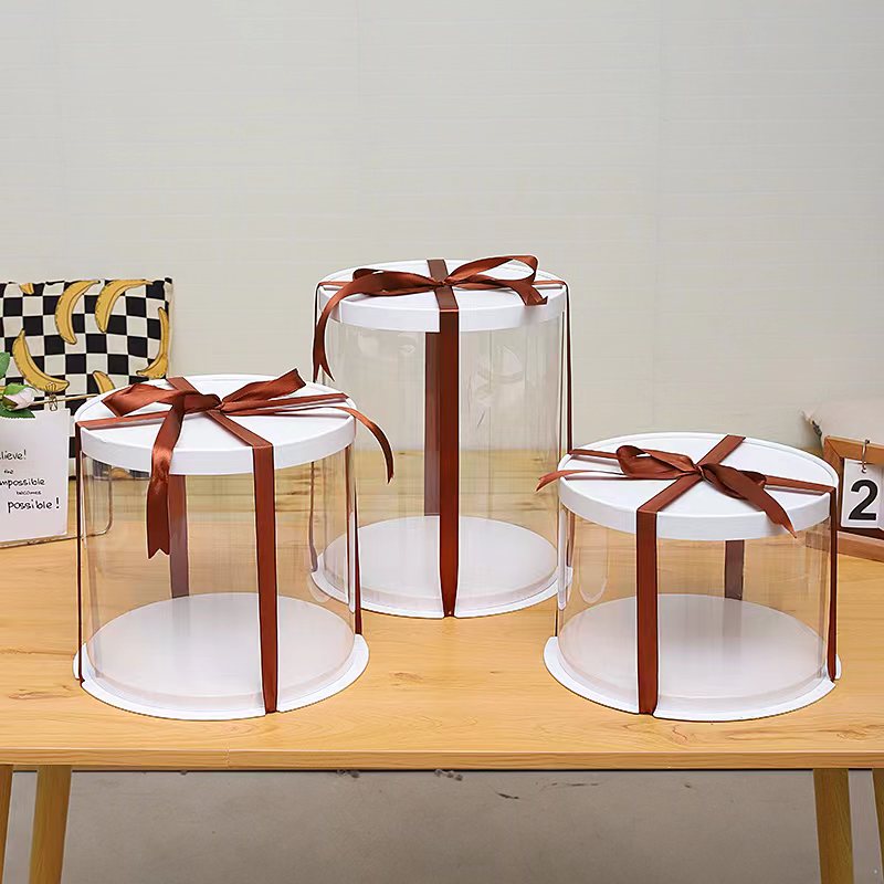 Circular transparent cake boxes wrapped in ribbon